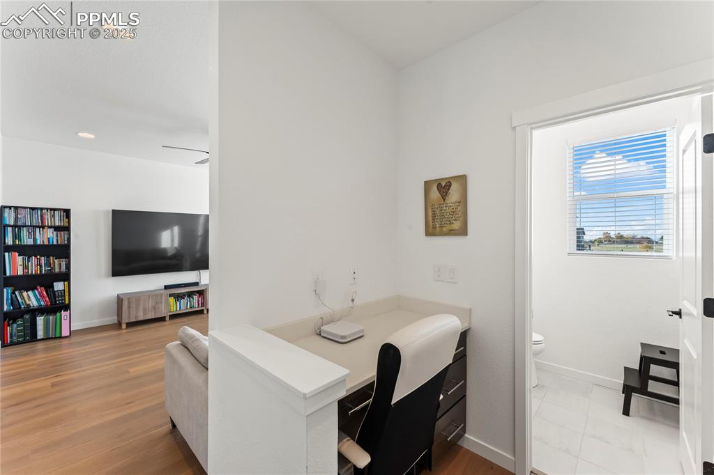 Image 16 of 31: Office with light wood finished floors and recessed lighting