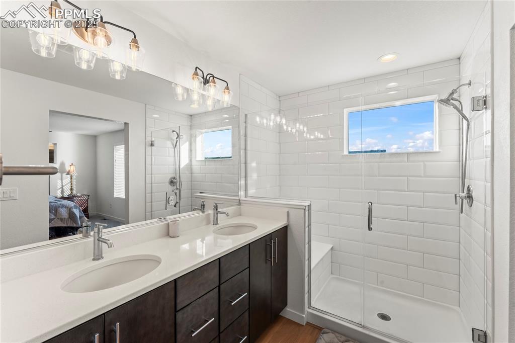 Image 23 of 31: Full bathroom featuring ensuite bath, double vanity, a shower stall, dark w