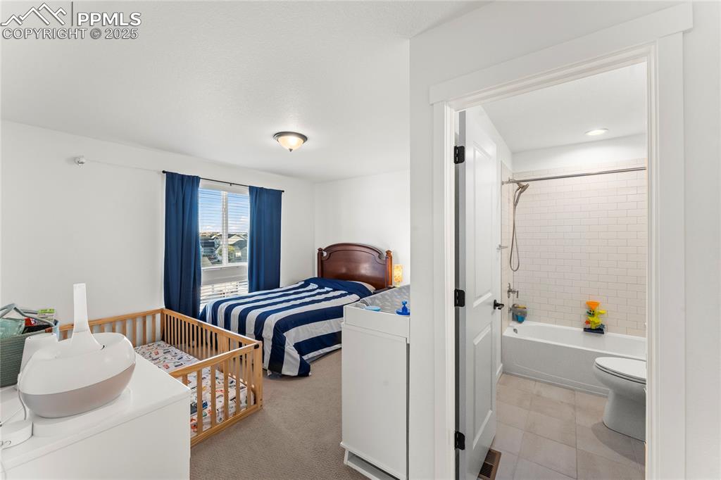 Image 24 of 31: Bedroom with light carpet, ensuite bathroom, and light tile patterned floor