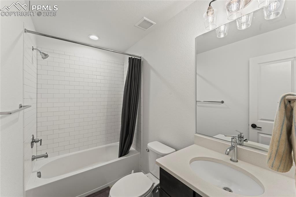 Image 26 of 31: Bathroom featuring shower / bath combination with curtain, vanity, and rece