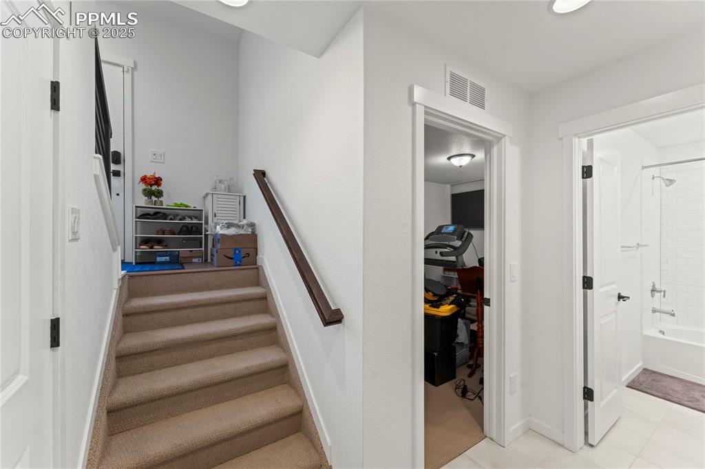 Image 27 of 31: Staircase with tile patterned flooring and recessed lighting