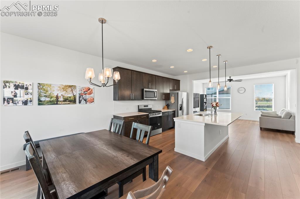 Image 7 of 31: Kitchen featuring hanging light fixtures, decorative backsplash, stainless