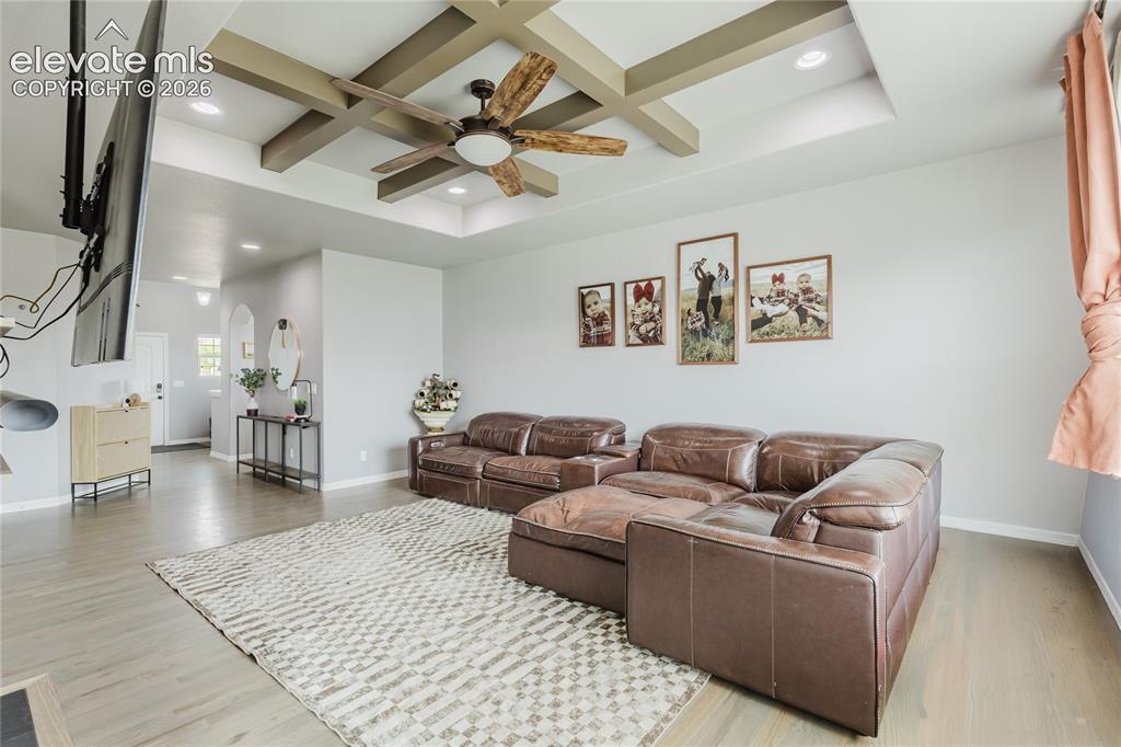 Image 11 of 46: Living area featuring a coffered ceiling with a wood-finish ceiling fan and