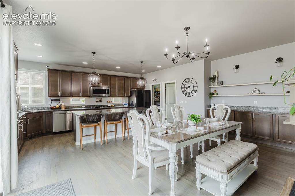 Image 12 of 46: Open-concept living space featuring wood-finish flooring, recessed lighting
