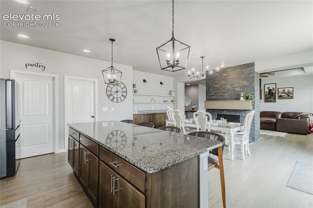 Image 17 of 46: Kitchen island with granite countertop and dark wood cabinetry