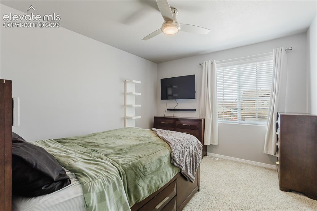 Image 21 of 46: Carpeted room featuring a ceiling fan with integrated lighting, a window wi
