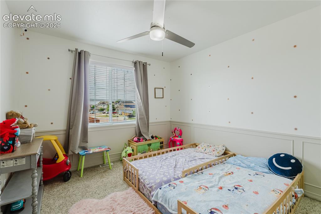 Image 23 of 46: Carpeted room featuring a ceiling fan with light fixture, window with blind