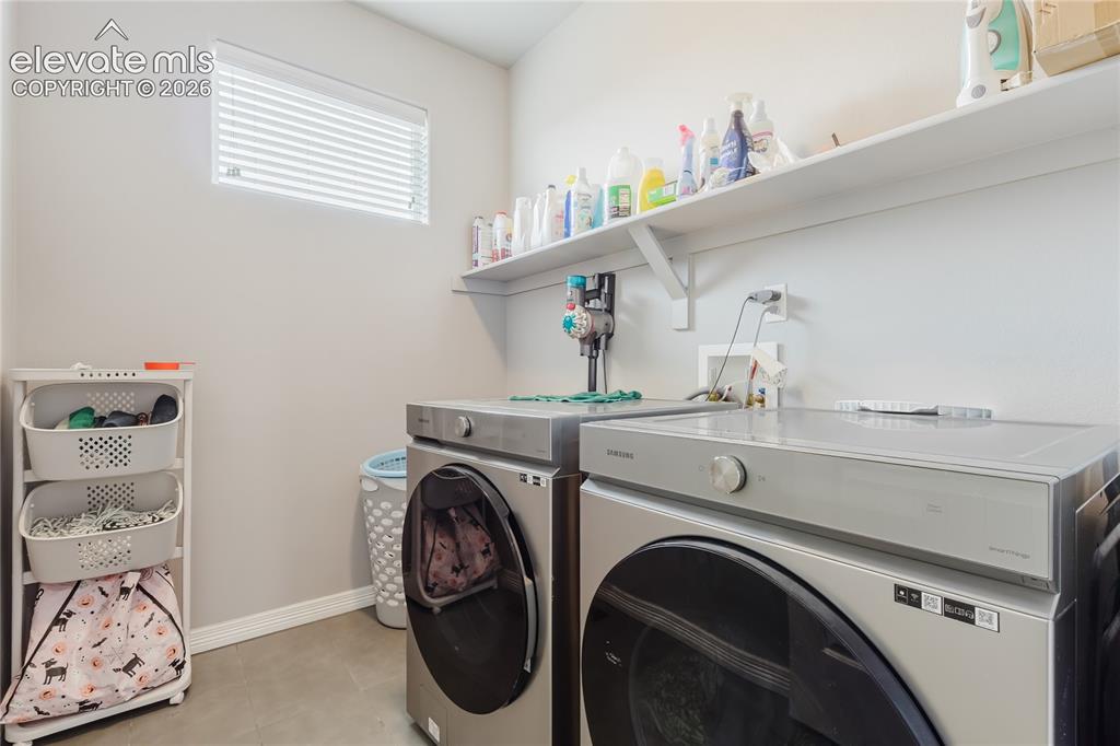 Image 25 of 46: Dedicated laundry space featuring a window with horizontal blinds, built-in
