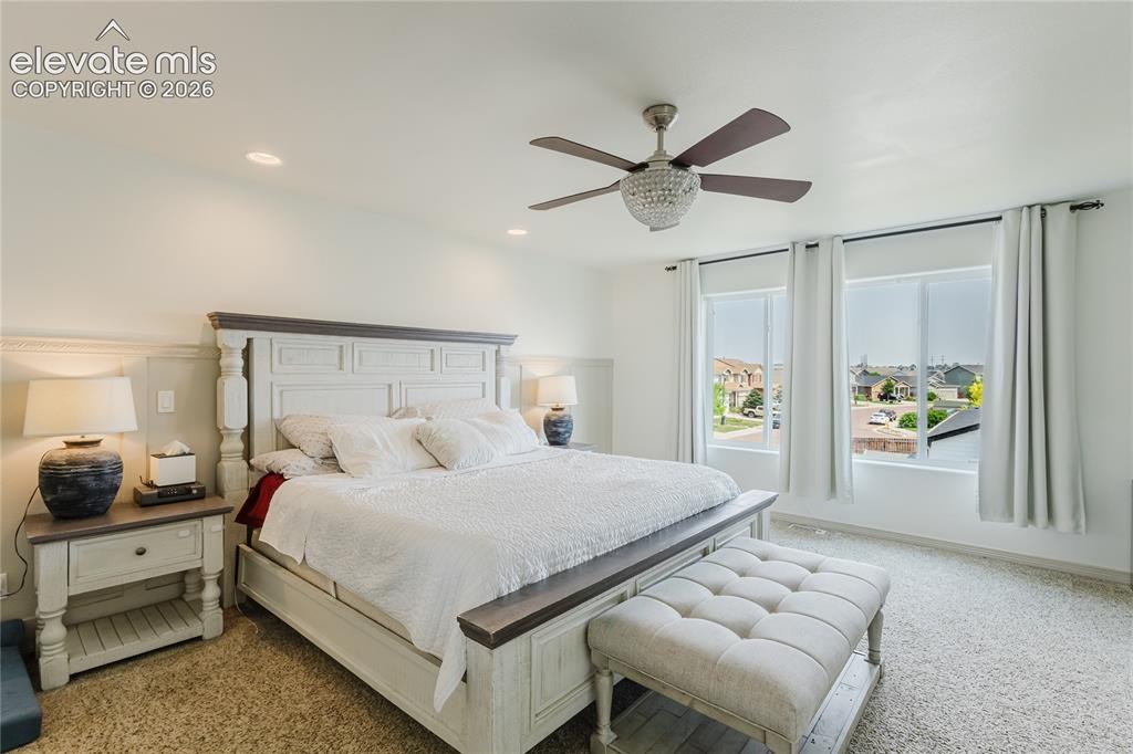 Image 29 of 46: Spacious bedroom featuring light-colored carpet, two large windows, a ceili