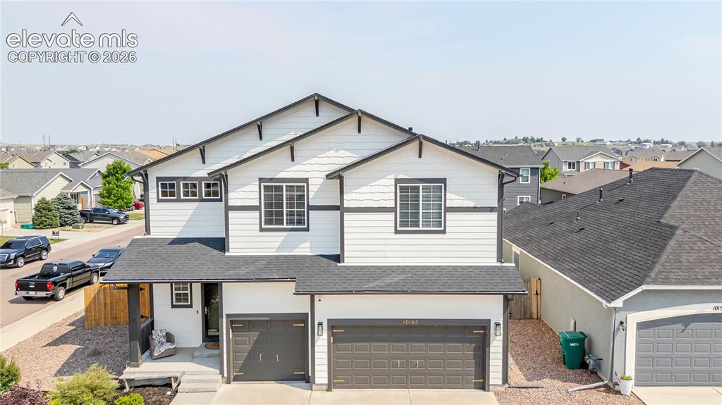 Image 3 of 46: Contemporary home with white siding and dark trim, featuring a two-car gara