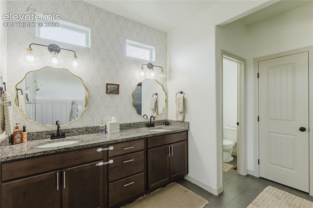 Image 33 of 46: Dual vanity with undermount sinks and granite countertops