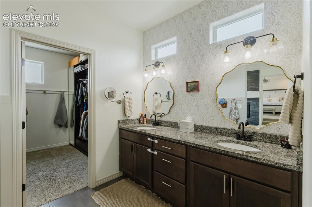 Image 34 of 46: Double vanity featuring granite countertops, undermount sinks, and matte bl