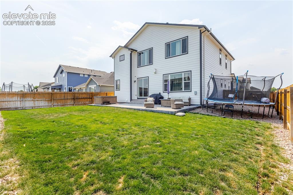 Image 41 of 46: Two-story white siding exterior featuring a ground-level patio, expansive l