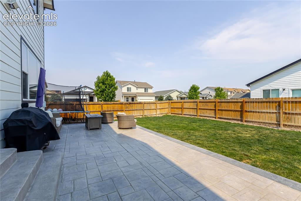 Image 42 of 46: Expansive backyard featuring a stamped concrete patio, a manicured lawn, a