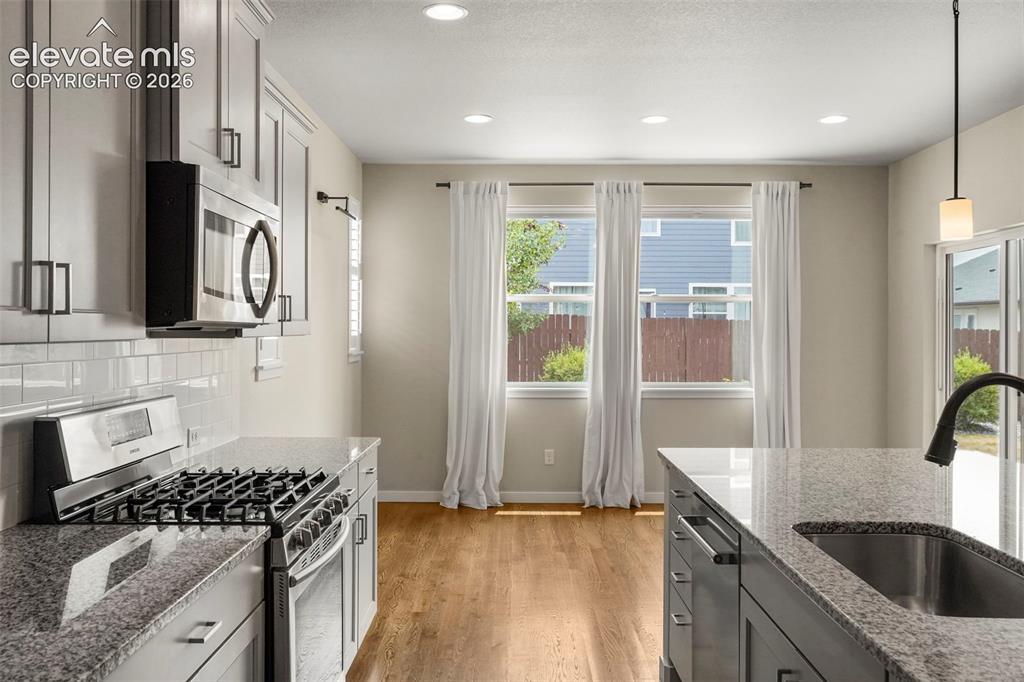 Image 11 of 37: Contemporary kitchen featuring light gray cabinetry, stainless steel applia