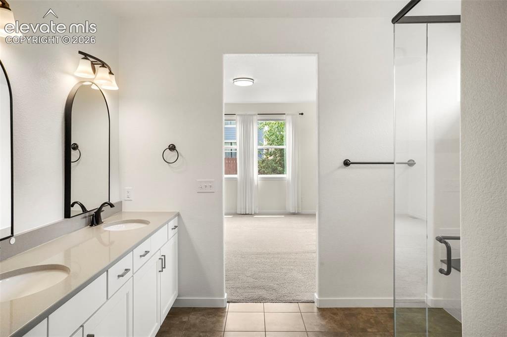 Image 16 of 37: Dual vanity with white cabinetry, light-toned countertop, and undermount si