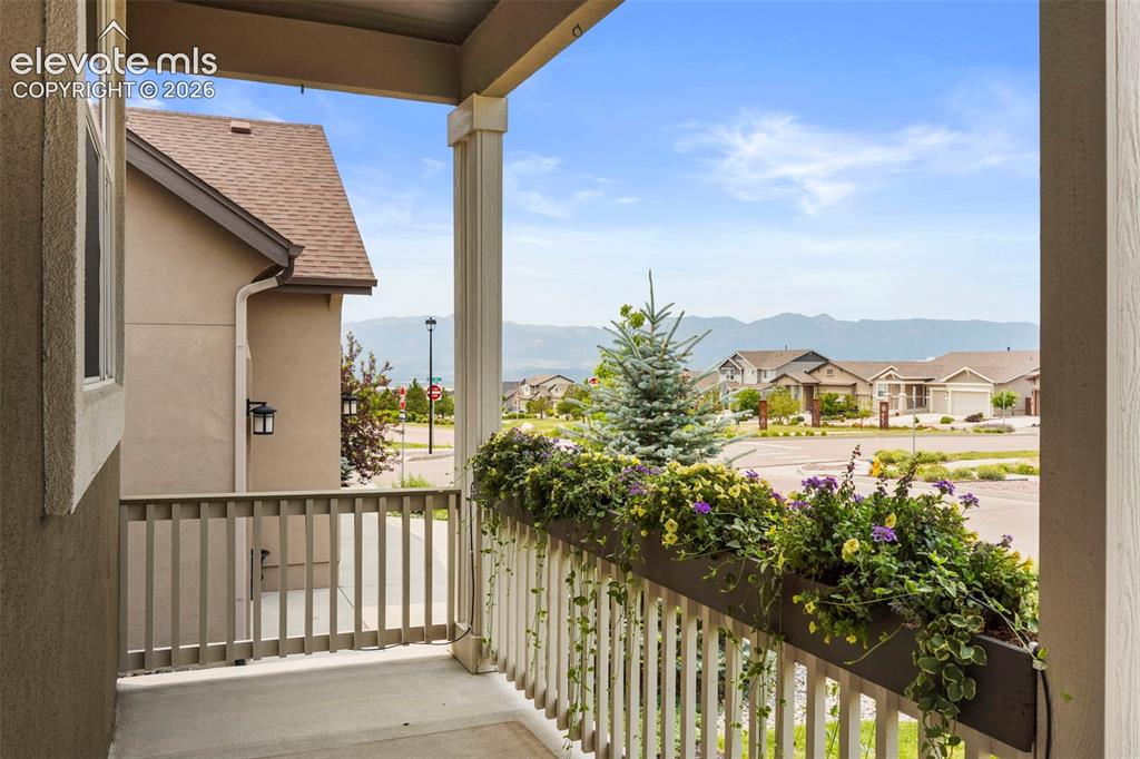Image 2 of 37: Covered front porch featuring a decorative wood railing, built-in planter b