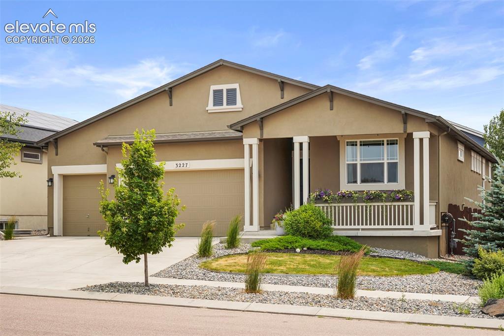 Image 36 of 37: Stucco exterior featuring a covered porch with white railing, a double gara