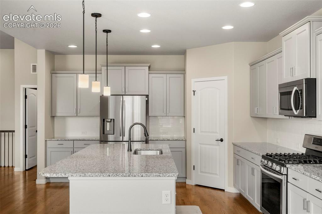 Image 8 of 37: Open-concept kitchen featuring an oversized island with an undermount sink,