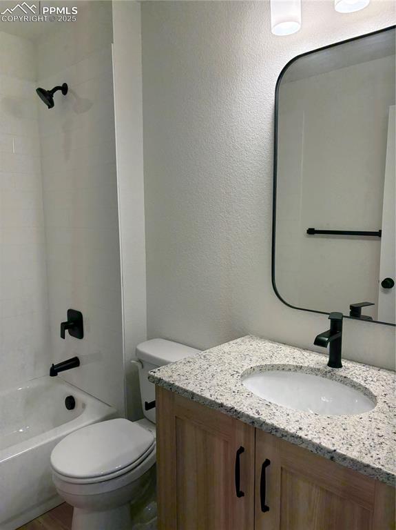 Image 5 of 22: Bathroom featuring vanity, shower / washtub combination, and a textured wal