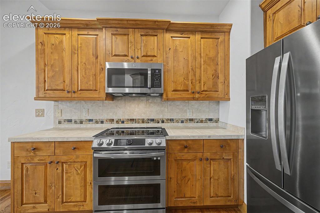 Image 17 of 42: Stainless steel appliances and gorgeous cabinets!