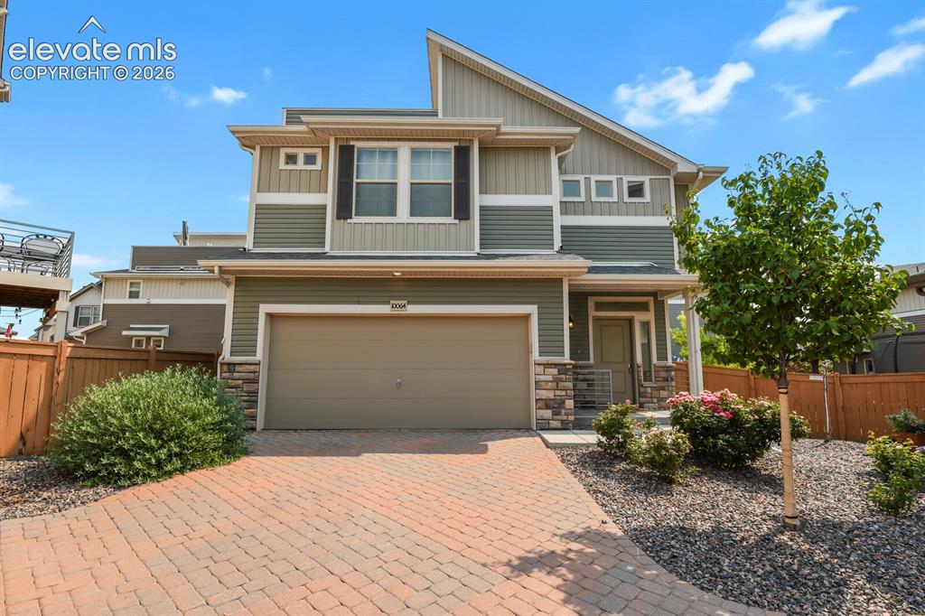 Image 1 of 31: Contemporary architecture featuring a two-car garage and a brick paver driv