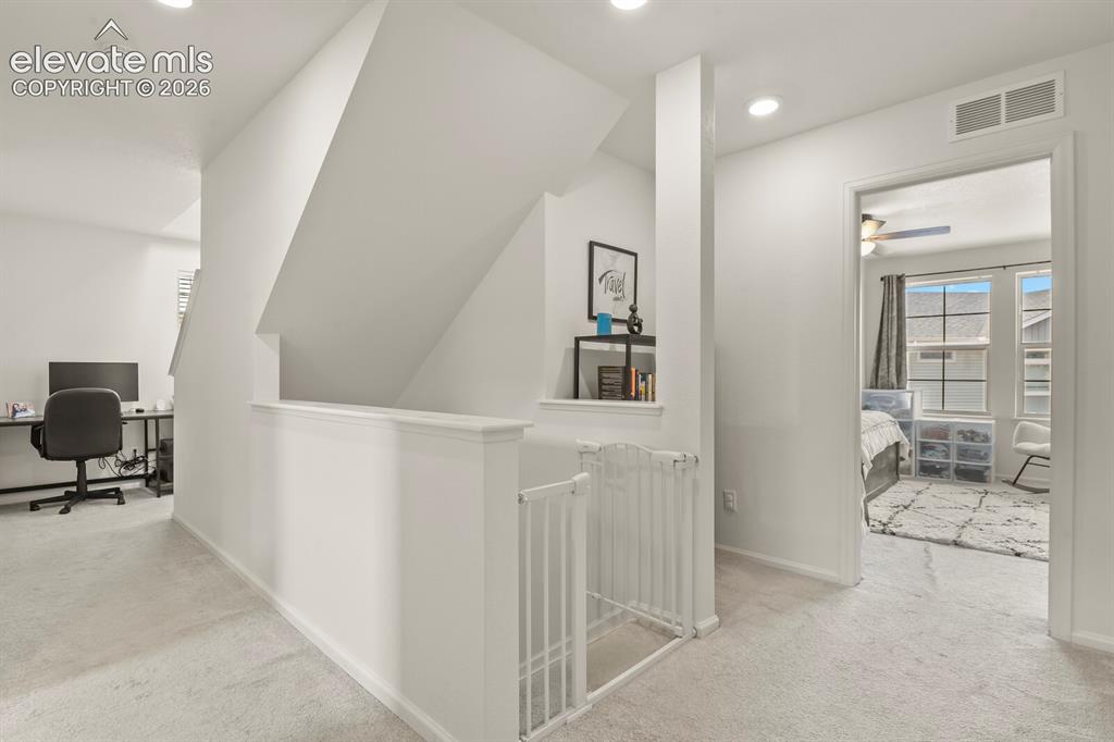 Image 14 of 31: Upper level carpeted landing featuring white walls, recessed lighting and a