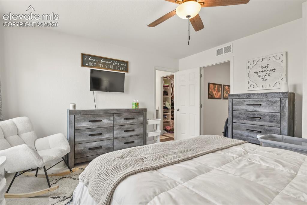Image 16 of 31: Spacious primary bedroom featuring dual windows, a ceiling fan with integra