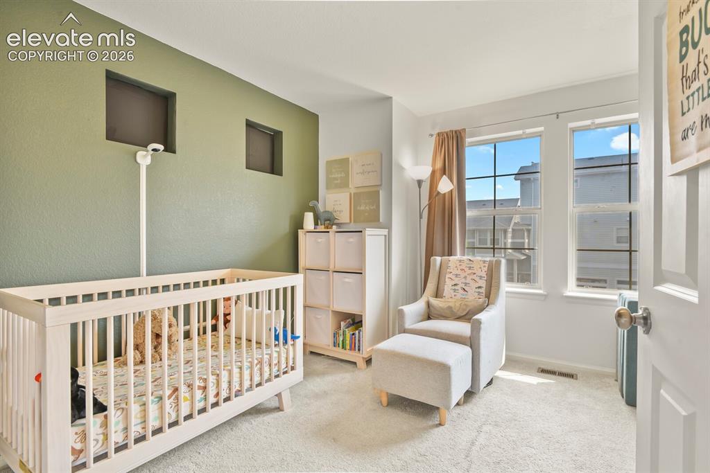 Image 18 of 31: Bedroom featuring soft green accent wall with two recessed wall niches and 