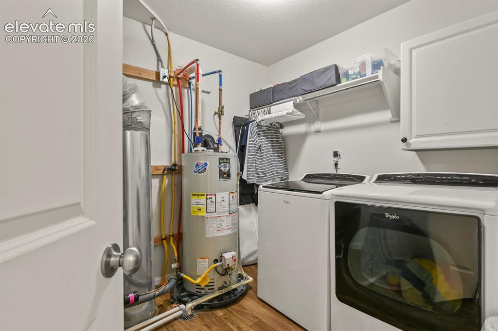 Image 24 of 31: Dedicated laundry area located on the upper level featuring wood flooring, 