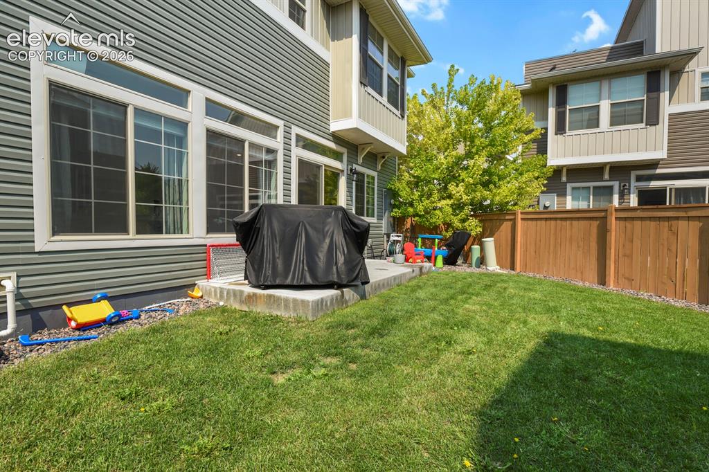 Image 27 of 31: Private backyard featuring a manicured lawn, concrete patio and privacy fen
