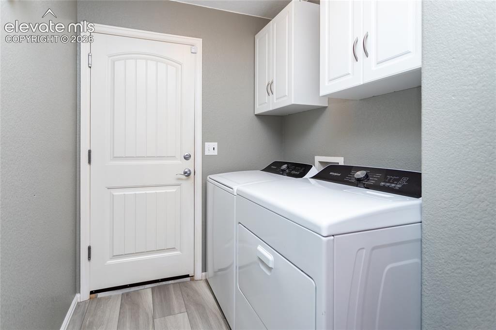 Image 27 of 49: Laundry room is conveniently located on the main level and offers storage c