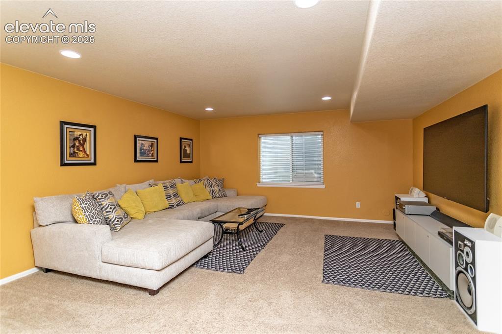 Image 30 of 49: Family room has a large entertainment area. TV mount stays with the home.
