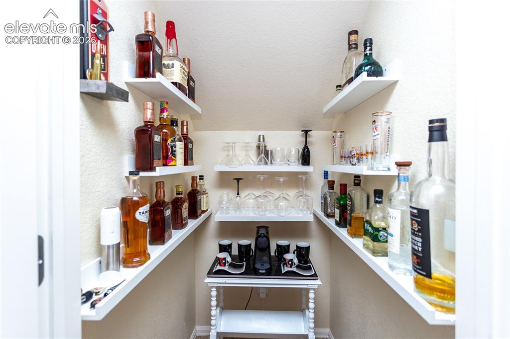 Image 33 of 49: Storage under the stairs is very cleverly turned into a dry bar area.