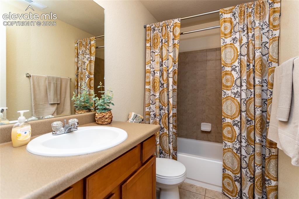 Image 34 of 49: Basement level full bathroom offers tile flooring and tile surround.