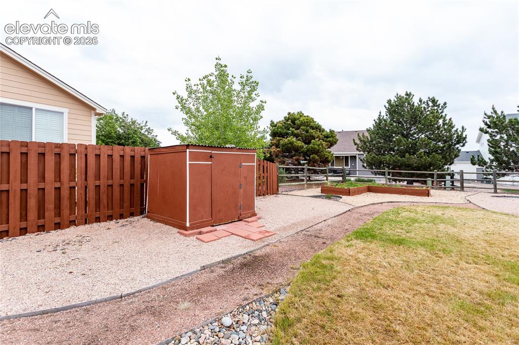 Image 45 of 49: Storage shed and a raised garden area.