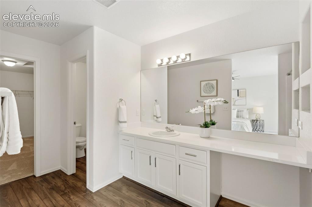 Image 23 of 38: Get ready with ease in the primary en-suite bathroom featuring a spacious v