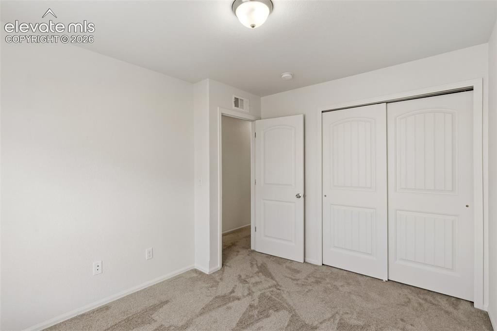 Image 30 of 38: Ample closet space in the secondary bedroom ensures you have all the storag