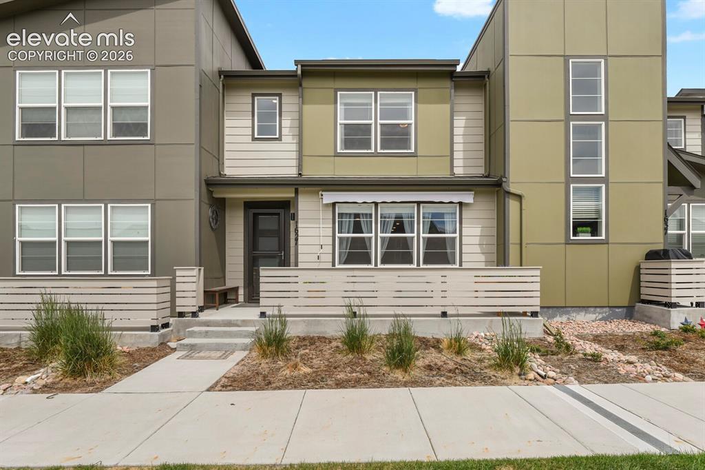 Caption: Contemporary multi-level residence featuring a multi-toned facade, a private patio with horizontal s