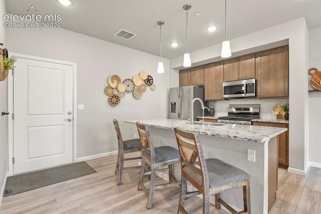Image 12 of 29: Kitchen featuring an island with granite countertop, stainless steel applia