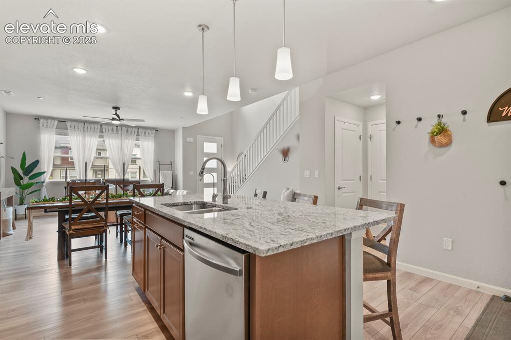 Image 14 of 29: Kitchen island featuring a granite countertop, undermount sink, and stainle