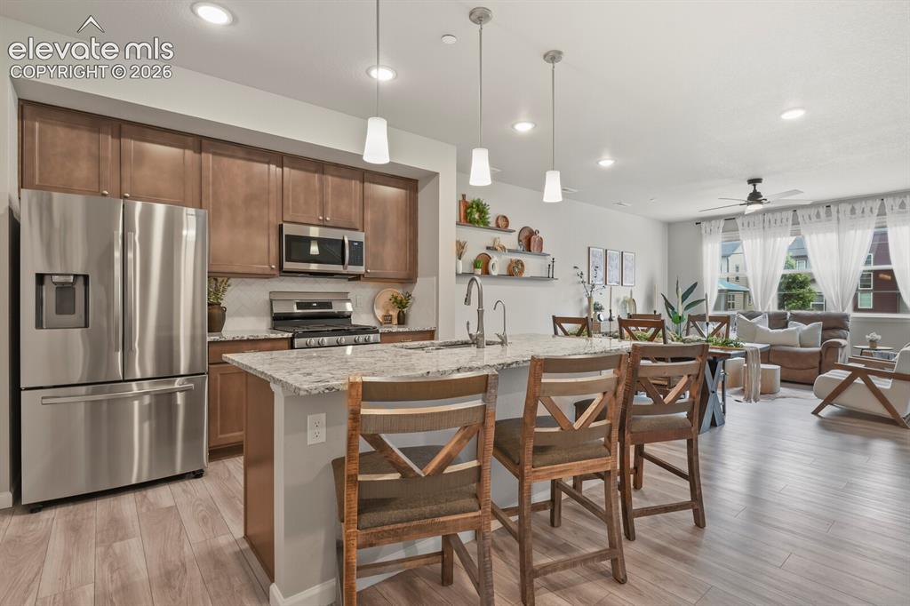 Image 15 of 29: Kitchen featuring stainless steel appliances, wood-finish cabinetry, a gran
