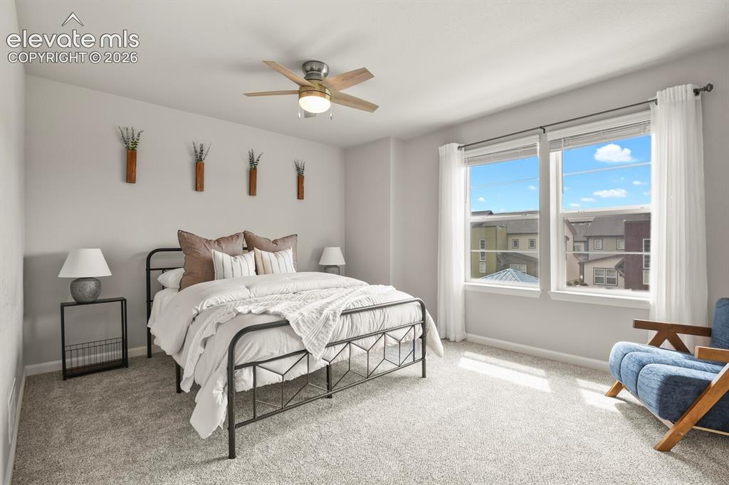 Image 16 of 29: Bright sleeping area featuring a ceiling fan with integrated lighting, two 