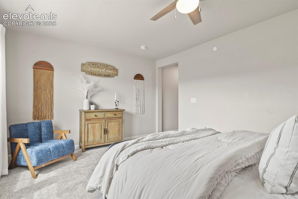 Image 17 of 29: Spacious room with light neutral walls and carpeted flooring