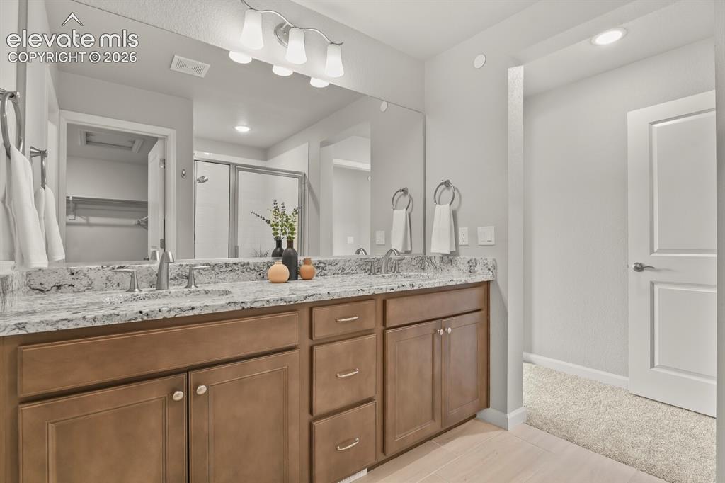 Image 18 of 29: Double vanity featuring a light-toned countertop, dual undermount sinks, an