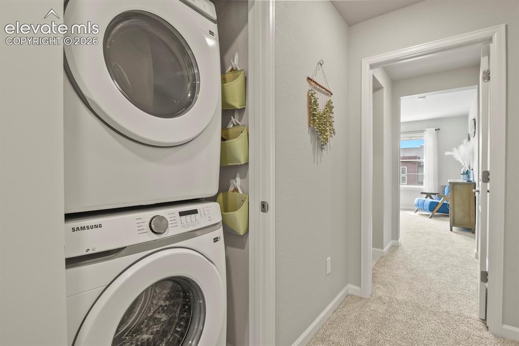 Image 21 of 29: Dedicated laundry closet featuring a stacked washer and dryer unit