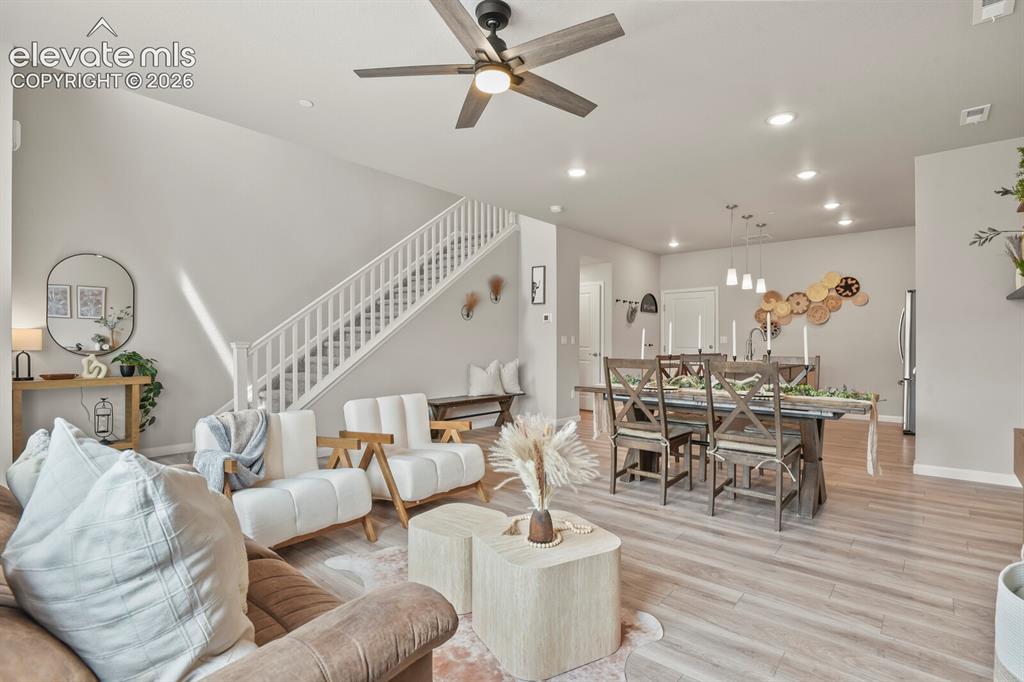 Image 6 of 29: Open-concept living space featuring wood-finish flooring, a ceiling fan wit