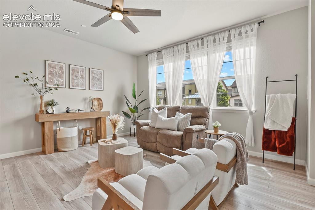 Image 7 of 29: Living area featuring light wood-finish flooring, light gray walls, and a c