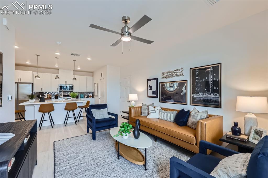 Image 4 of 10: Living area with light wood-type flooring, recessed lighting, and a ceiling