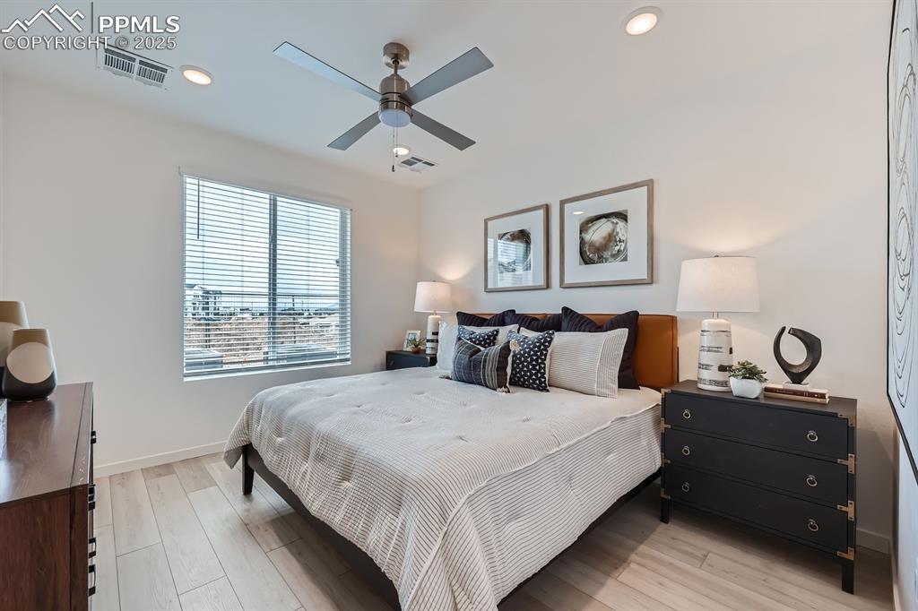 Image 7 of 10: Bedroom with light wood-type flooring, ceiling fan, and recessed lighting